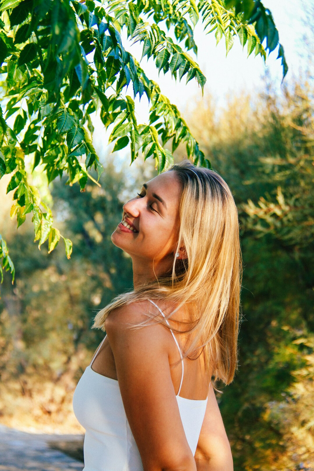 Portrait of a smiling woman with light hair outdoors